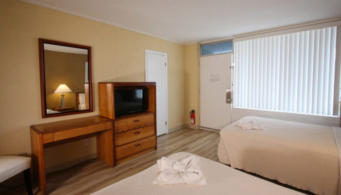 a room with two beds and a television vacation rental