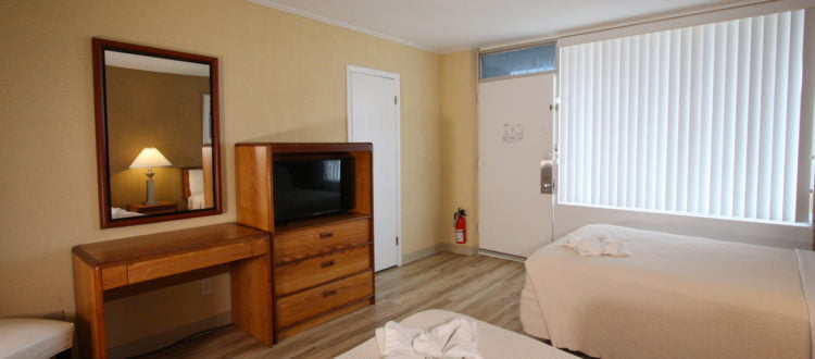 a room with two beds and a television vacation rental